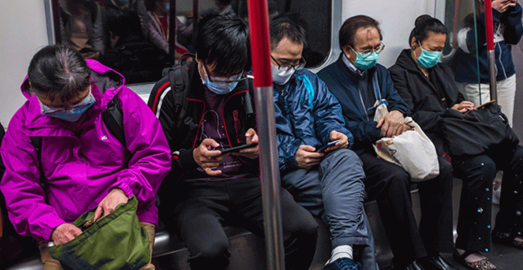 Ihmiset käyttävät hengityssuojaimia HongKongissa.