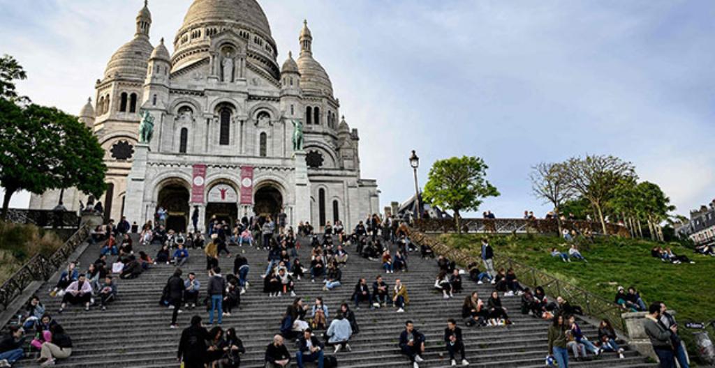 Ihmiset istuivat Sacré-Coeurin kirkon portailla Ranskan pääkaupungissa Pariisissa 12. toukokuuta.