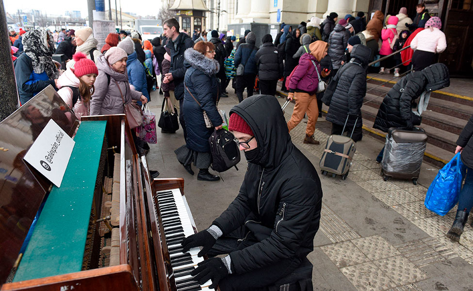 Mies soitti pianoa Lvivin rautatieaseman edessä Länsi-Ukrainassa, kun ihmiset pakenivat. Kuva otettiin 6. maaliskuuta.
