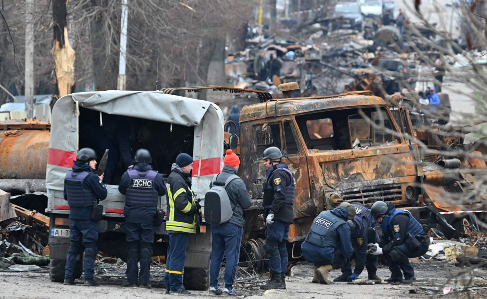 Kuva on Butšan kaupungin kadulta. Kuva on otettu sen jälkeen, kun Venäjän sotilaat vetäytyivät kaupungista. Pelastustyöntekijät raivaavat kadulta sotilaiden ajoneuvoja, jotka ovat tuhoutuneet taisteluissa.