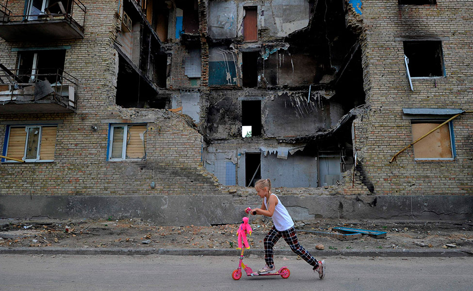 Tyttö liikkuu potkulaudalla Horenkan kylässä Kiovan alueella.