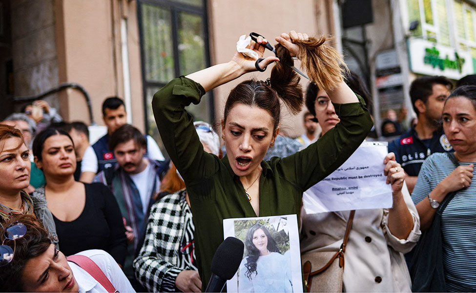 Naiset osoittivat mieltään Turkin Istanbulissa viime perjantaina. Mielenosoitus oli vastalause sille, että Iranin siveyspoliisi pidätti 22-vuotiaan kurdinaisen. Nainen kuoli myöhemmin poliisin väkivallan takia. Kuvassa on iranilainen Nasibe Samsaei. Hän leikkaa poninhäntänsä vastalauseena Iranin politiikalle. Kuva otettiin Istanbulissa Iranin konsulaatin edessä.