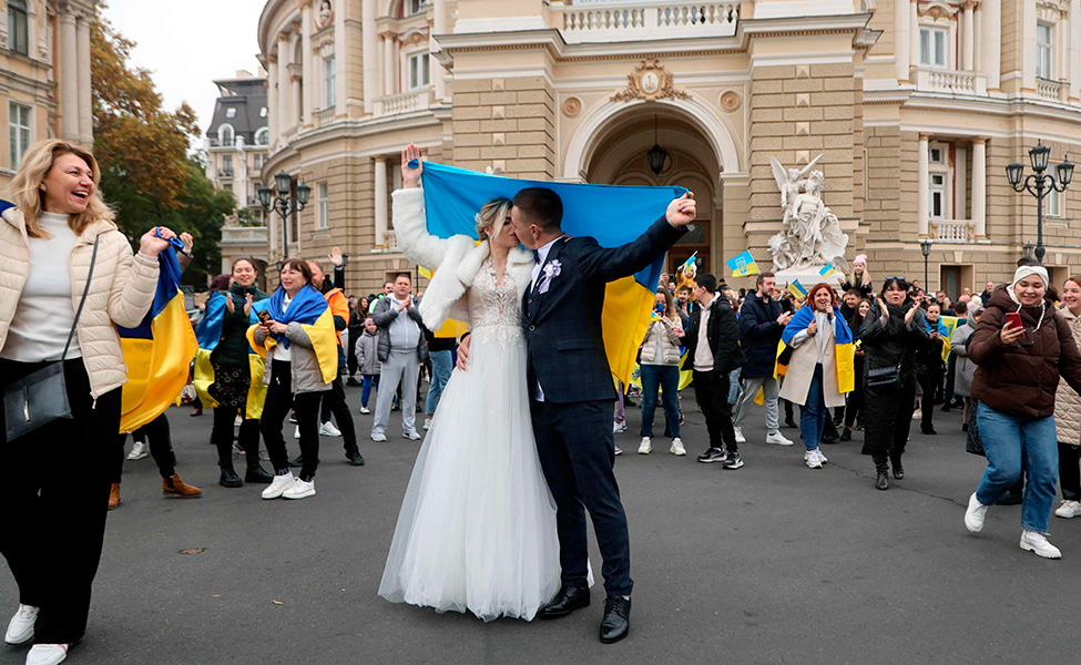 Ukrainalainen aviopari juhli häitään Ukrainan kansallisoopperan edessä Odessassa 12. marraskuuta. Aviopari piteli Ukrainan lippua.