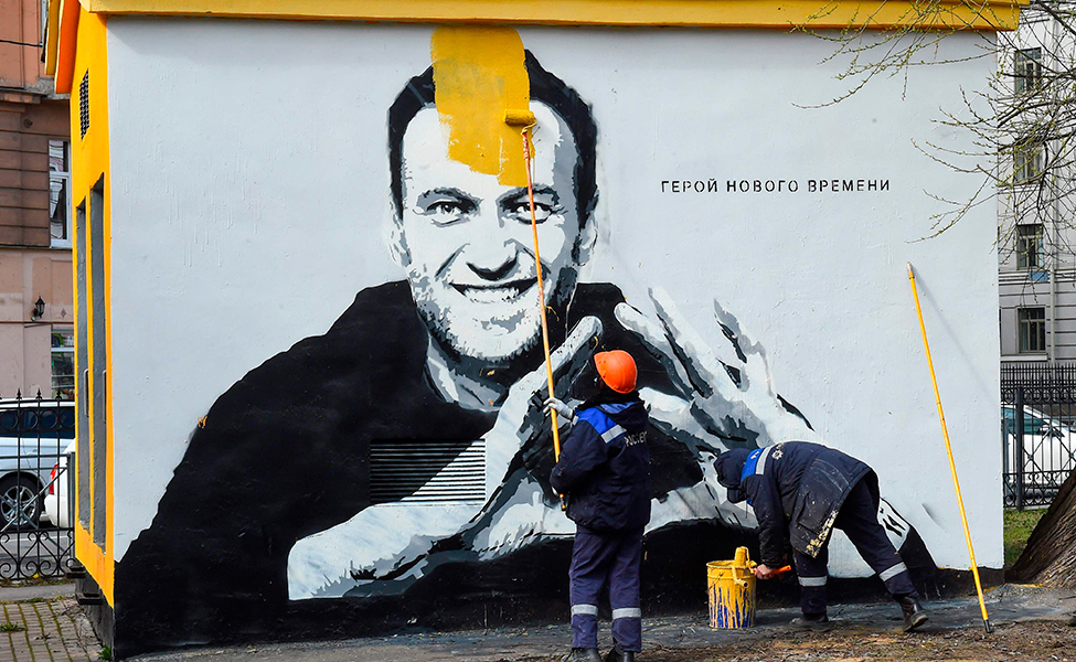 Aleksei Navalnyin kuvan päälle maalataan Pietarissa. Navalnyi on vastustanut Vladimir Putinin hallintoa.