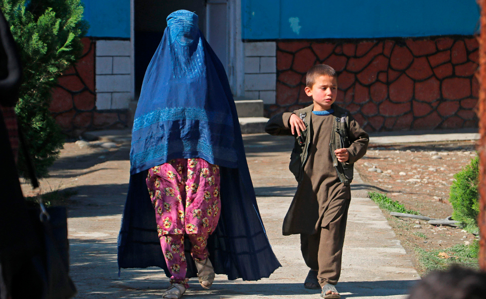 Kuvassa afganistanilainen nainen kävelee pojan kanssa Feyzabadin kaupungissa Afganistanissa.