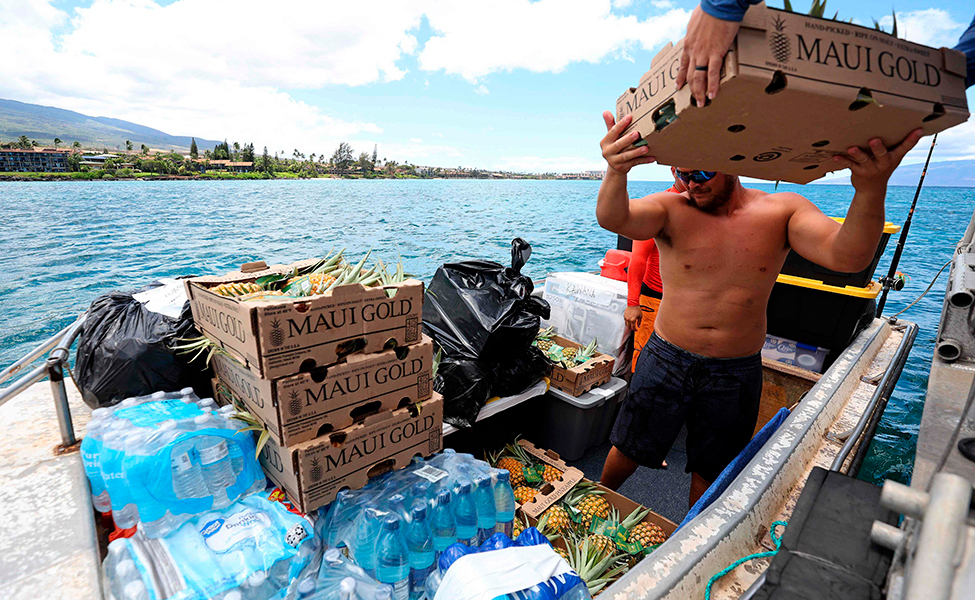 Vapaaehtoiset avustustyöntekijät kuljettivat ananaslaatikoita Kaanapaliin Länsi-Mauin saarelle Havaijilla 14. elokuuta.