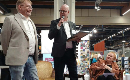 Presidentti Tarja Halonen, Kultti ry:n puheenjohtaja Tuomas Rantanen ja Selkosanomien päätoimittaja Petri Kiuttu lavalla Helsingin kirjamessuilla.